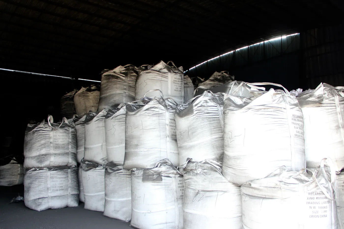 Worker bagging calcined anthracite into PP bags